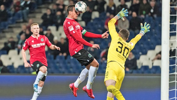 Edgar Prib von Hannover 96 (M.) scheitert mit einem Kopfball an Holstein Kiels Keeper Ioannis Gelios © imago images / foto2press 