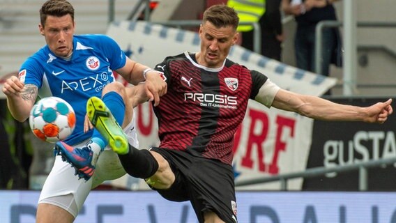 Ingolstadts Marcel Gaus (l) kommt vor Rostocks Bentley Baxter Bahn an den Ball. © picture alliance/dpa | Stefan Puchner 