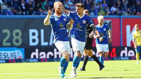 Hansa Rostocks Nils Fröling (l.) und Sebastien Thill feiern einen Treffer gegen Bröndby. © IMAGO / Jan Huebner 