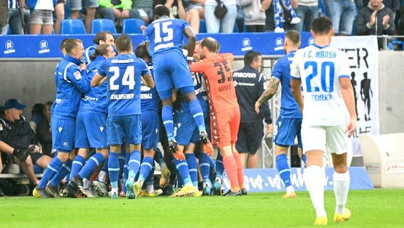 Die Spieler vom Karlsruher SC bejubeln einen Treffer gegen Hansa Rostock. © IMAGO/Lobeca 