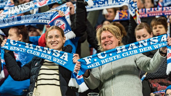 Weibliche Fans des FC Hansa Rostock schwenken Schals © IMAGO / Fotostand 