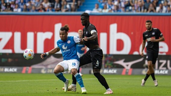 Rostocks Juan Jose Perea (l.) und Maxwell Gyamfi (VfL Osnabrück) im Zweikampf © Imago / Fotostand 