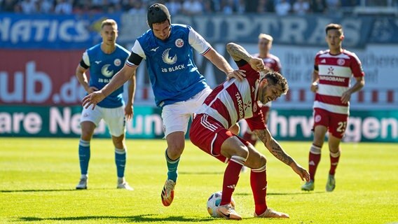 Hansa Rostocks Damian Roßbach im Duell mit Düsseldorfs Matthias Zimmermann © picture alliance / dpa 