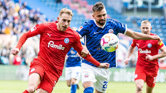 Timo Becker (l.) von Holstein Kiel im Duell mit Lukas Hinterseer von Hansa Rostock © picture alliance / Fotostand | Fotostand / Voelker 