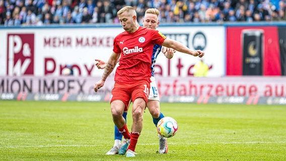 Lewis Holtby (v.) von Holstein Kiel im Duell mit Kai Pröger vom FC Hansa Rostock © IMAGO / Fotostand 