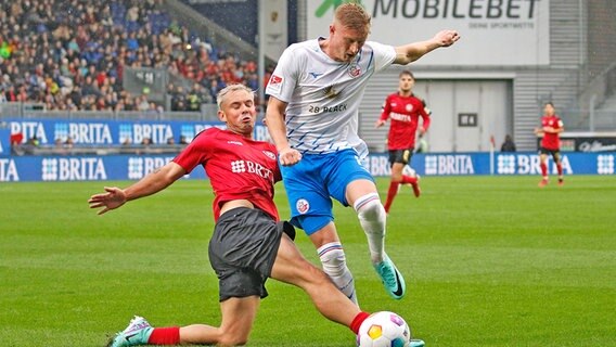 Kevin Schumacher (r.) vom FC Hansa Rostock im Duell mit Thijmen Goppel vom SV Wehen Wiesbaden © IMAGO / Jan Huebner 