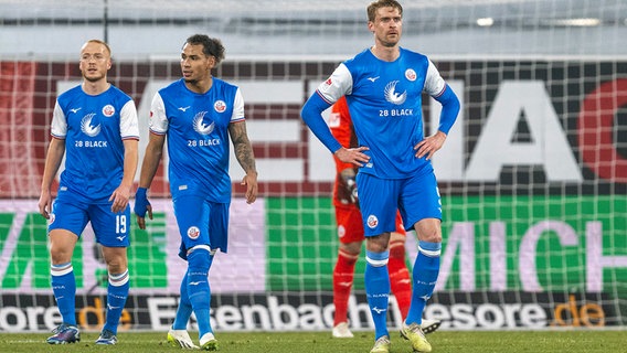 Rostocks Sebastian Vasiliadis (v.li.), Rostocks Juan Jose Perea und Rostocks Oliver Hüsing sind enttäuscht © picture alliance / dpa 