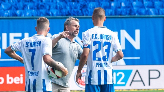 Hansa-Trainer Bernd Hollerbach bei einer Besprechung. © imago / Ostseephoto 