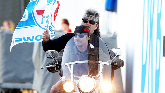 Mike Werner (Meisterteam, r.) lässt sich mit einer Harley zur Auswechselbank fahren - mit Fahne und Vokuhila-Perücke. © fishing4 