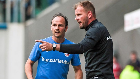 Rostocks Christian Brand (l.) diskutiert mit Co-Trainer Uwe Ehlers. © Imago/Eibner 
