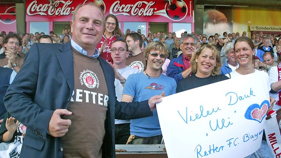 Manager Uli Hoeneß vom FC Bayern München im "Retter-T-Shirt" im Millerntorstadion des FC St. Pauli (Foto aus dem Jahr 2003) © IMAGO / Bernd König 