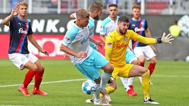 Simon Terodde (2.v.l.) vom FC Schalke 04 im Duell mit Holstein Kiels Torwart Ioannis Gelios