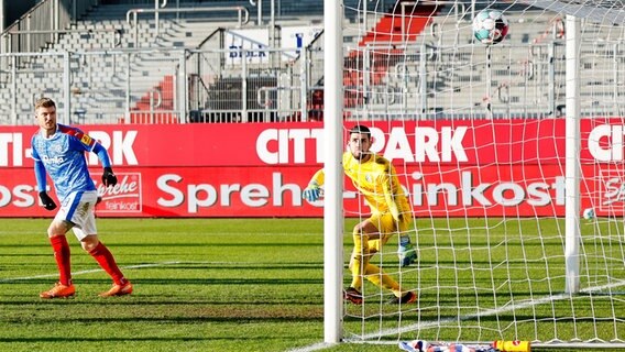 Alexander Mühling (l.) und Keeper Ioannis Gelios von Holstein Kiel schauen zu, wie der Ball im Spiel gegen den Karlsruher SC zum 0:2 im Tor einschlägt © picture alliance/dpa Foto: Frank Molter