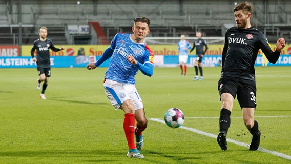 Kiels Fabian Reese (l.) spielt den Ball an Würzburgs Christian Strohdiek vorbei. © picture alliance / dpa Foto: Frank Molter