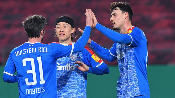 Die Kieler Fußballer Fin Bartels, Jae-sung Lee und Janni Serra (v.l.) bejubeln ein Tor. © IMAGO / Revierfoto 