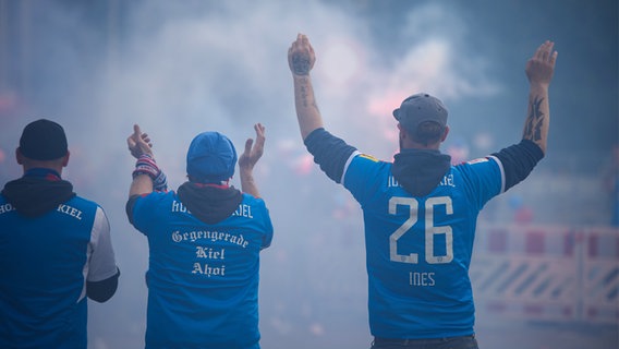 Fans des KSV Holstein klatschen vor dem Holstein-Stadion in die Hände. © dpa - Bildfunk Foto: Gregor Fischer