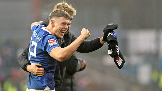 Nicolai Remberg und Tom Rothe (v.l.) von Holstein Kiel bejubeln den 1:0-Erfolg gegen den FC Schalke 04 © IMAGO / Claus Bergmann 