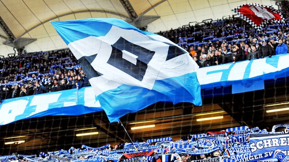 HSV-Fans im Volksparkstadion schwenken eine große Fahne. © Witters Foto: Frank Peters
