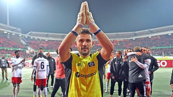 HSV-Keeper Daniel Heuer Fernandes bedankt sich nach dem Zweitunden-Sieg im DFB-Pokal beim 1. FC Nürnberg bei den mitgereisten Fans. © IMAGO / Jan Huebner 