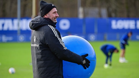 HSV-Trainer Tim Walter trägt einen großen blauen Ball vor sich her. © Witters 