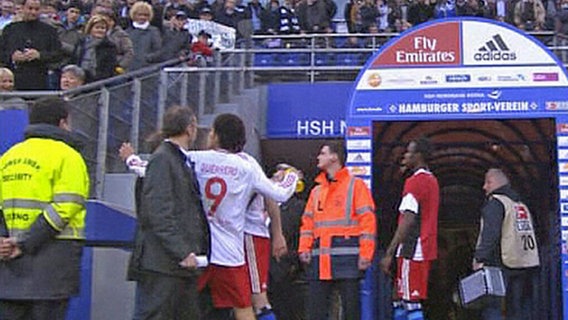 HSV-Profi Paolo Guerrero (M), der am 4.4.2010 eine Trinkflasche in Richtung eines Fans auf der Tribüne wirft und den Zuschauer am Kopf trifft. © picture alliance / dpa | Sky 