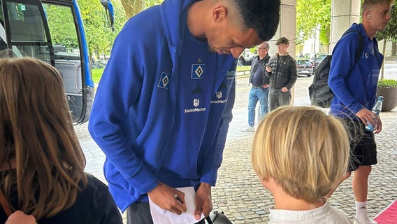 HSV-Spieler Robert Glatzel schreibt Autogramme vor dem Teamhotel in Hamburg © NDR 