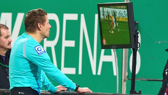 Schiedsrichter Patrick Ittrich sieht sich eine Szene auf dem Videobildschirm an. © IMAGO / Action Pictures 