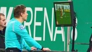 Schiedsrichter Patrick Ittrich sieht sich eine Szene auf dem Videobildschirm an. © IMAGO / Action Pictures 