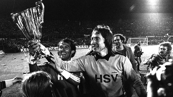 HSV-Torhüter Rudi Kargus (r.) und Georg Volkert gehen 1977 nach dem Triumph im Finale gegen RSC Anderlecht mit dem Pokalsieger-Cup auf die Ehrenrunde. © picture-alliance / Sven Simon 
