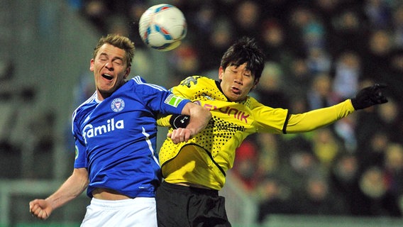 Holstein Kiels Rafael Kazior (l.) im Kopfballduell mit Dortmunds Shinji Kagawa. © IMAGO / Ulmer 