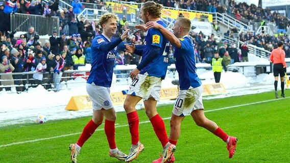 Kiels Finn Porath (l.), Fiete Arp (Mitte) und Lewis Holtby jubeln. © IMAGO / KBS-Picture 