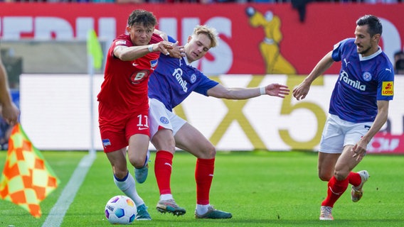 Berlins Fabian Reese (l.) im Duell mit den Kielern Finn Porath (M.) und Steven Skrzybski. © picture alliance / Eibner-Pressefoto 