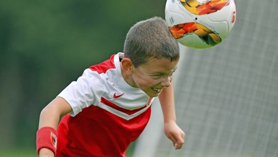 Ein Kind beim Kopfball © IMAGO / MIS 