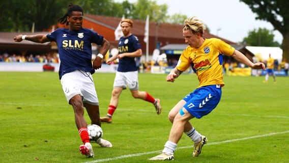 Obinna Iloka (l.) vom 1. FC Phönix Lübeck und Marco Drawz vom SV Todesfelde kämpfen um den Ball. © IMAGO / Lobeca 