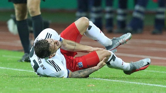 HSV-Profi Tim Leibold wälzt sich schwer verletzt auf dem Rasen. © IMAGO / Zink 