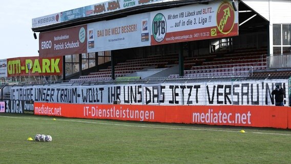 Im Stadion des VfB Lübeck auf der Lohmühle hängt ein Banner, mit dem die Fans gegen die Leistungen des Drittligisten protestieren © IMAGO / Lobeca 