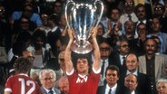 HSV-Profi Felix Magath stemmt 1983 die Trophähe für den Europapokalsieg der Landesmeister in den Athener Himmel. © imago/WEREK 