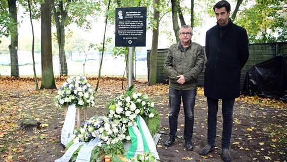 Jonas Boldt (r.) mit Roland Maleika vor der Gedenktafel für dessen verstorbenen Bruder Adrian. © Witters 