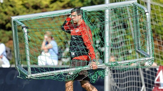 Thomas Meggle trägt 2010 beim Training des FC St. Pauli ein Tor.  