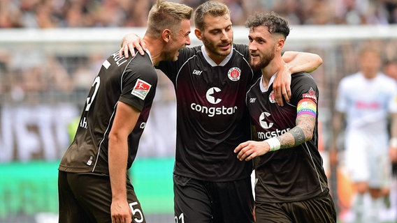 Hauke Wahl (l.), Lars Ritzka (Mitte) und Marcel Hartel, Spieler des FC St. Pauli, jubeln. © Imago Images 