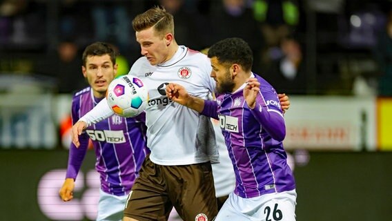 Johannes Eggestein vom FC St. Pauli (M.) versucht, sich gegen die Osnabrücker Dave Gnaase (r.) Bashkim Ajdini durchzusetzen © IMAGO/eu-images 