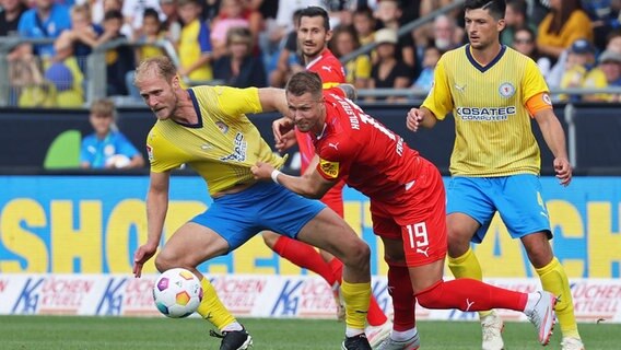 Braunschweigs Sebastian Griesbeck (l.) und Kiels Holbert Fridjonsson kämpfen um den Ball. © IMAGO / Susanne Hübner 