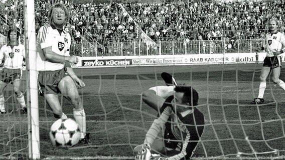HSV-Stürmer Horst Hrubesch trifft am 16.10.1982 in der zweiten Runde des DFB-Pokals im Spiel gegen Werder Bremen zum 1:1-Ausgleich gegen Torwart Dieter Burdenski. © picture-alliance / dpa 