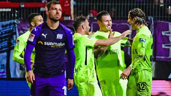 Osnabrücks Kevin Wolze vor jubelnden Spielern des SV Wehen Wiesbaden © imago images/Revierfoto 