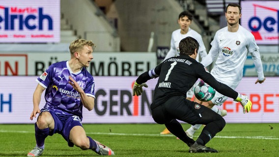 Osnabrücks Bryan Henning (l.) schaut dem Ball hinterher, den Aues Keeper Martin Männel fängt. © imago images / revierfoto 