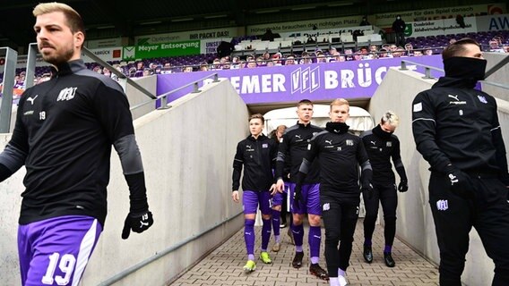 Die Spieler des VfL Osnabrück auf dem Weg zum Spielfeld im Stadion an der Bremer Brücke © IMAGO / Revierfoto 