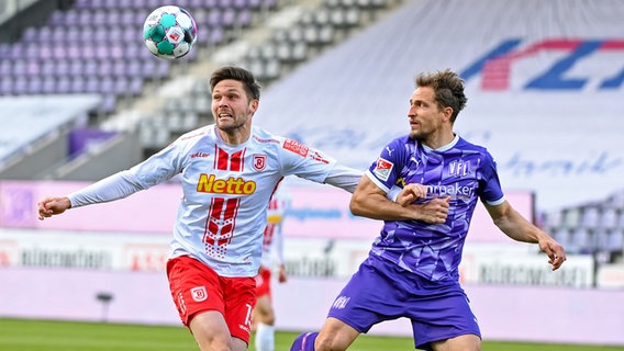 Regensburgs Andreas Albers (l.) behauptet den Ball gegen Osnabrücks Ulrich Taffertshofer. © picture alliance / Nico Paetzel 