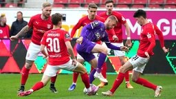 Osnabrücks Sebastian Klaas im Zweikampf mit mehrern Spieler des Halleschen FC