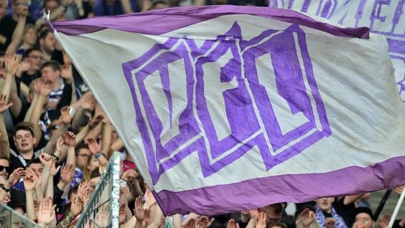 Fans schwenken eine Fahne des VfL Osnabrück. © IMAGO / osnapix 
