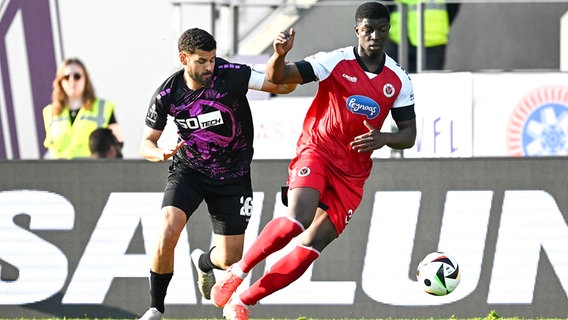 Dave Gnaase (l.) vom VfL Osnabrück im Duell mit Zoumana Keita von Viktoria Köln © IMAGO / osnapix 